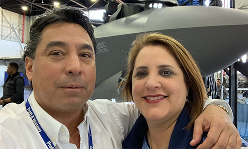 a man and woman standing in front of a jet