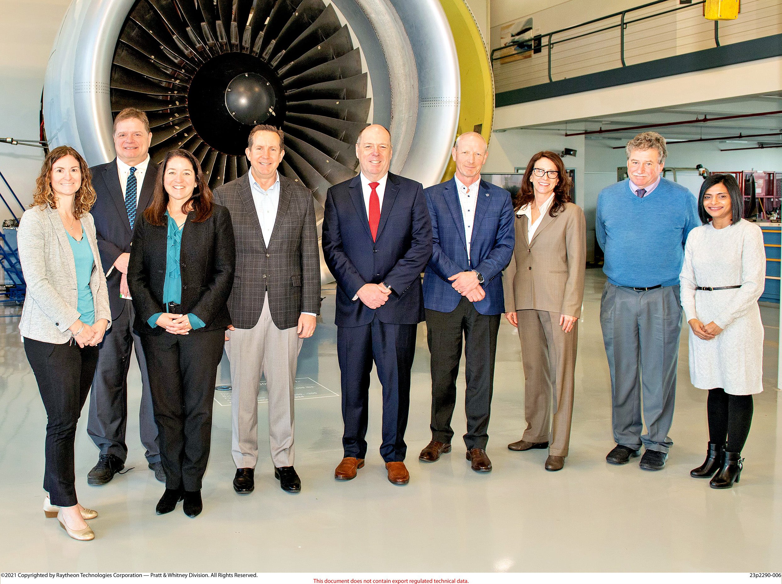 a line of people standing in front of a jet engine
